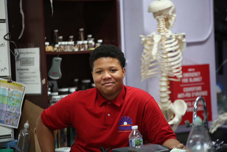student in classroom smiling at camera