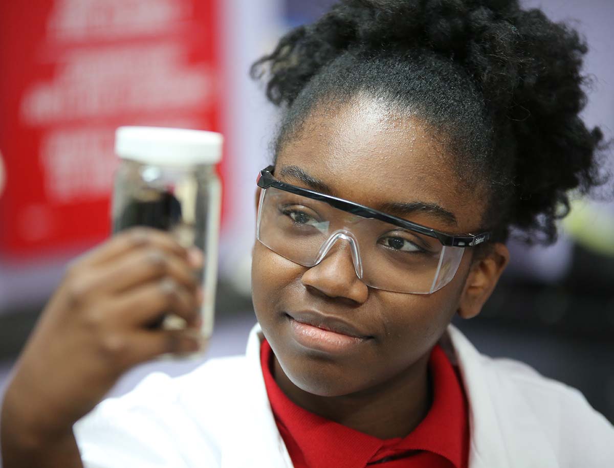 Elementary student smiling and posing together in a classroom.