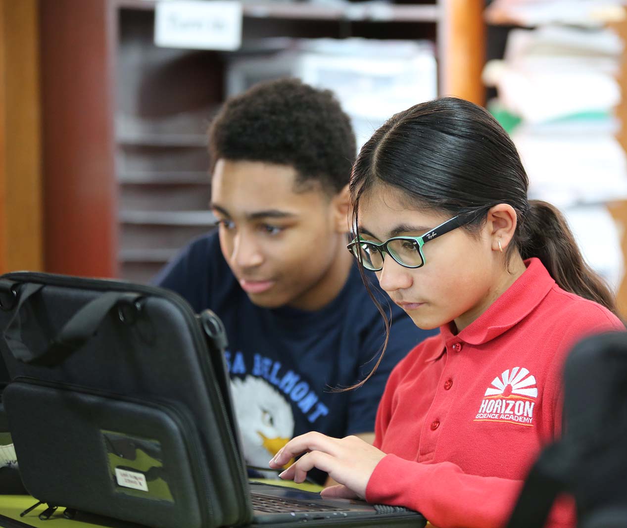 Student working on a notebook in a classroom.